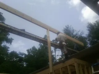 Carpenter setting a ridge beam over a new addition frame — Ice Dam Removal by Roofing Brothers in Hazel Park
