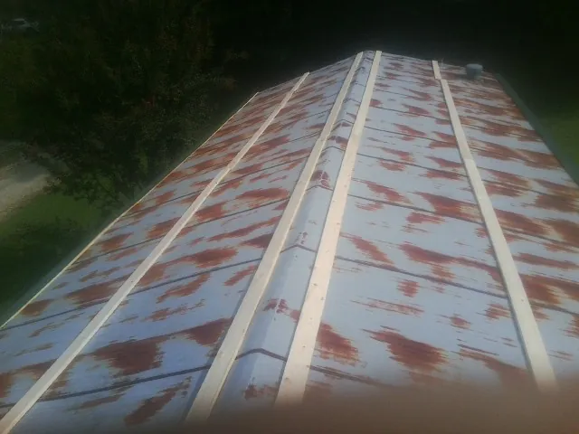 Rusted metal roof panels with new wood purlins before replacement — Storm Damage Roof Repair in Hazel Park by Roofing Brothers