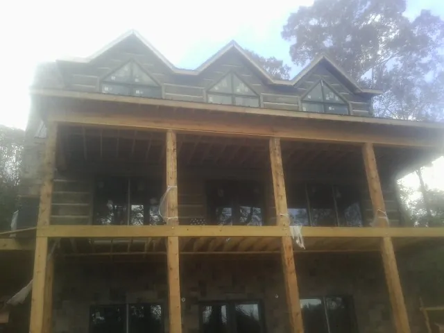Dormers and porch framing on a large log home under construction — Roof Coating work by our crew in Hazel Park