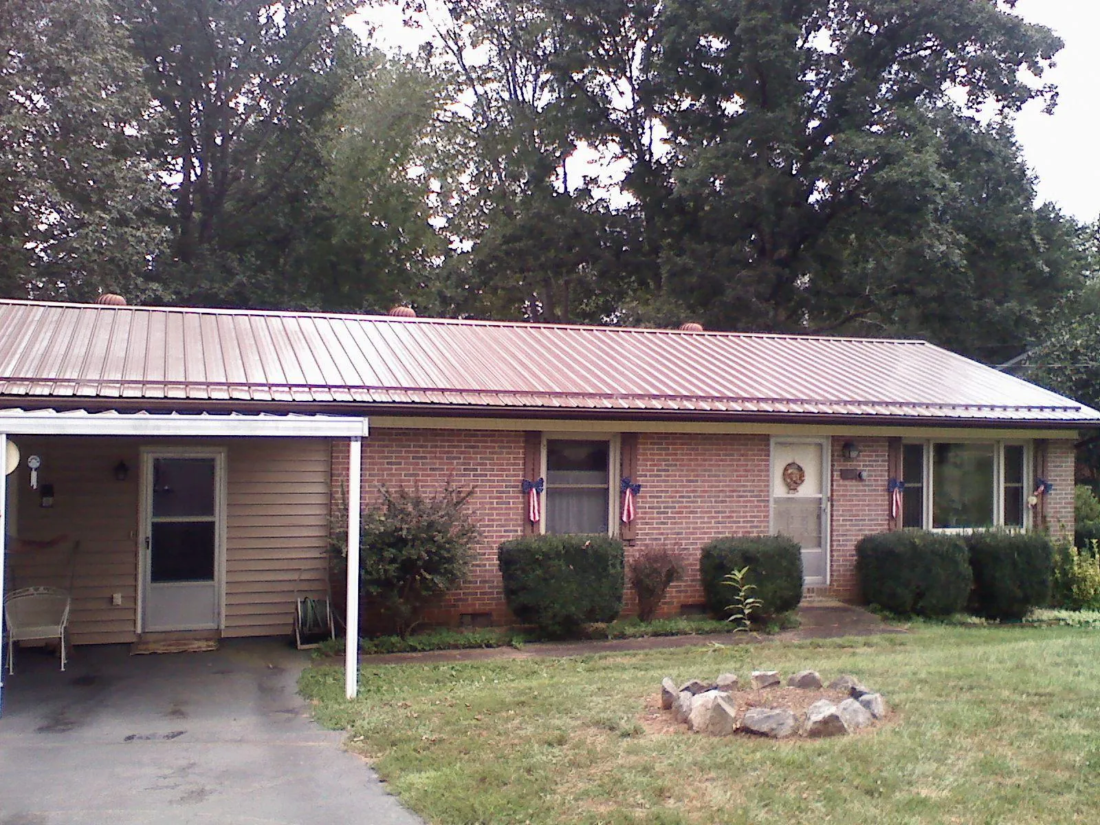 Bronze metal roof and carport on a brick ranch home — Roof Repair work by our crew in Hazel Park