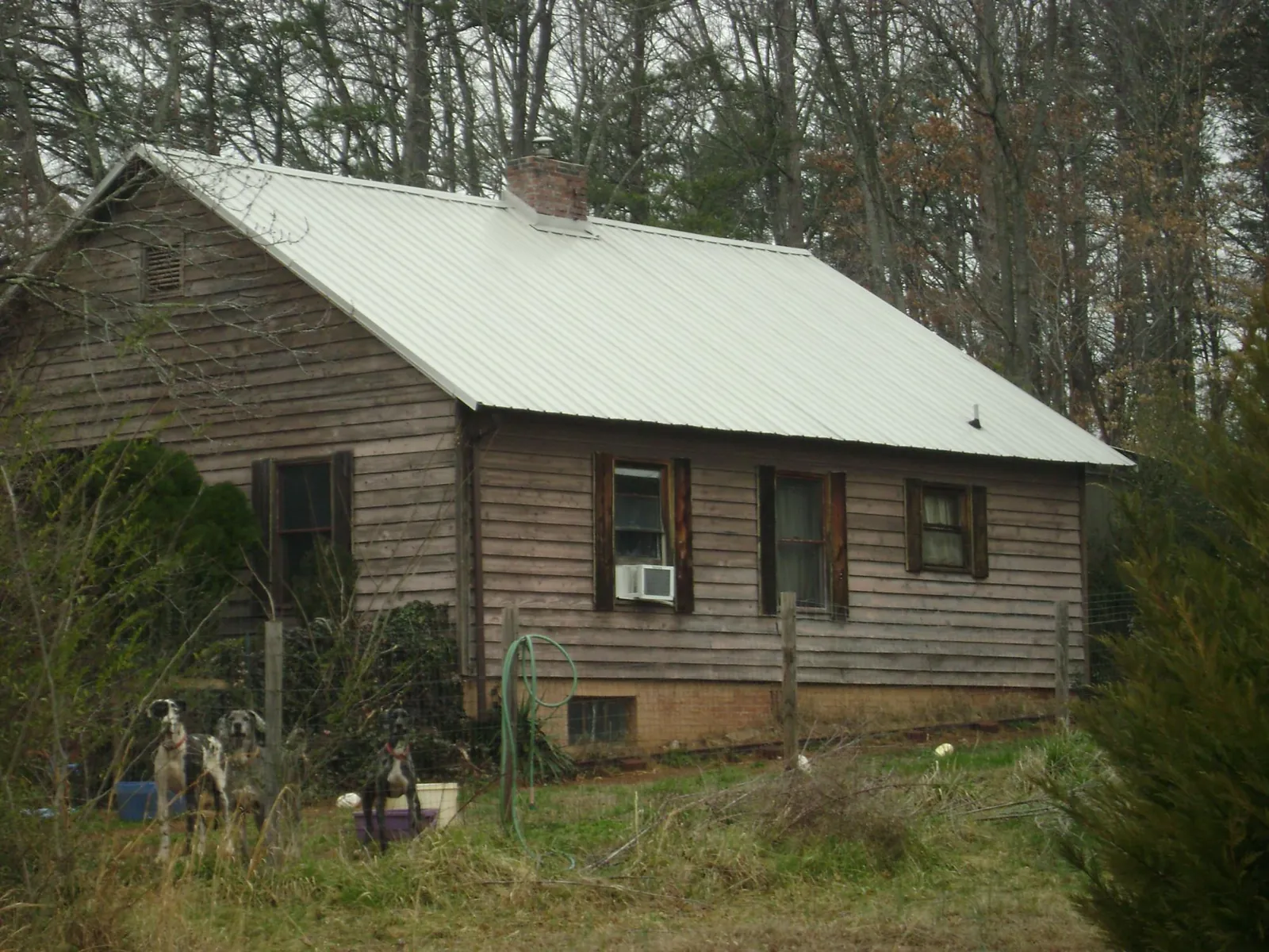 White metal roof on an old wood sided farmhouse, from a Metal Roof Installation job in Hazel Park